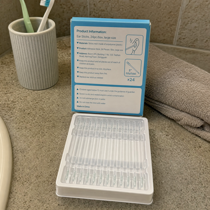 The sticks on a bathroom shelf beside a toothbrush cup