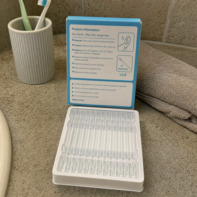 The sticks on a bathroom shelf beside a toothbrush cup